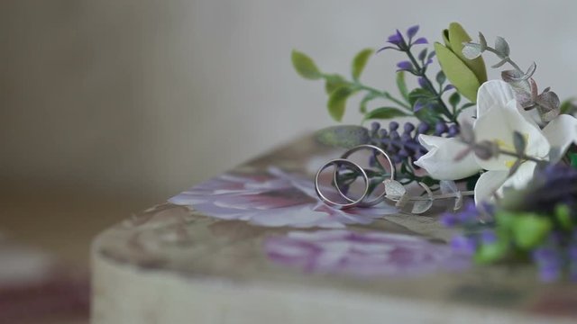 wedding rings with flowers on a table