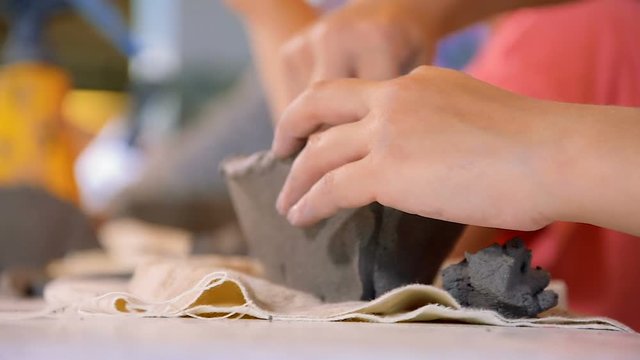 Kid makes clay boat during art classes in the ceramics workshop