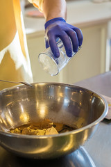 Hand pours water into a bowl. Preparing cakes
