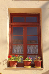 Obraz na płótnie Canvas Old rural window with flower pots, Crete, Greece.