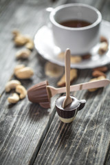 chocolates with tea and nuts on wooden background
