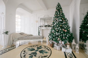 Christmas morning. classic luxury apartments with a white fireplace, decorated tree, bright sofa, large windows