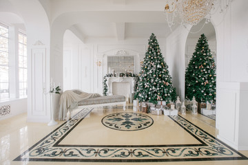 Christmas morning. classic luxury apartments with a white fireplace, decorated tree, bright sofa, large windows