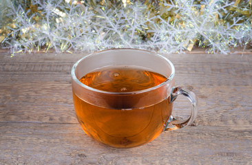 Cup of tea at Christmas background and old wooden surface.
