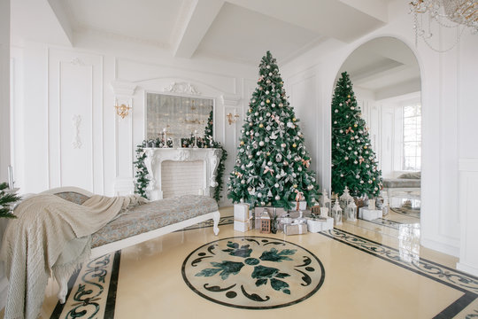 Christmas morning. classic luxury apartments with a white fireplace, decorated tree, bright sofa, large windows
