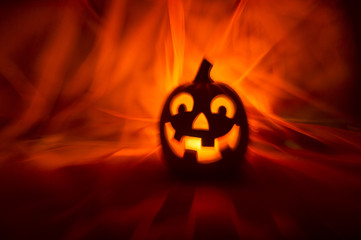 Spooky Halloween Jack-o-Lantern glowing on a bright orange background with mysterious motion blur...