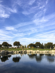 Relaxation scene of a park with a lake on a blue sky.