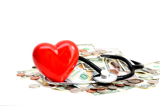 Red Heart And Stethoscope Resting On Pile Of Dollars