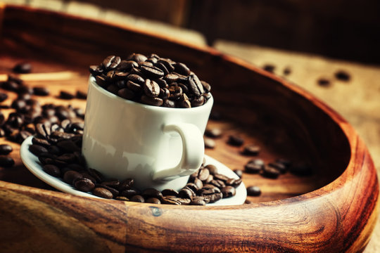 Coffee beans in a cup on a tray, selective focus