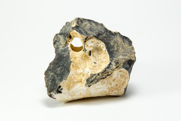 macro shooting of natural mineral stone - black flint (chert) crystalline rock isolated with hole on white background (Hühnergott)