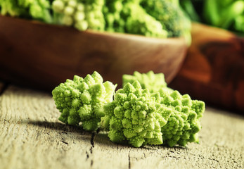 Green cauliflower, old wooden background, selective focus