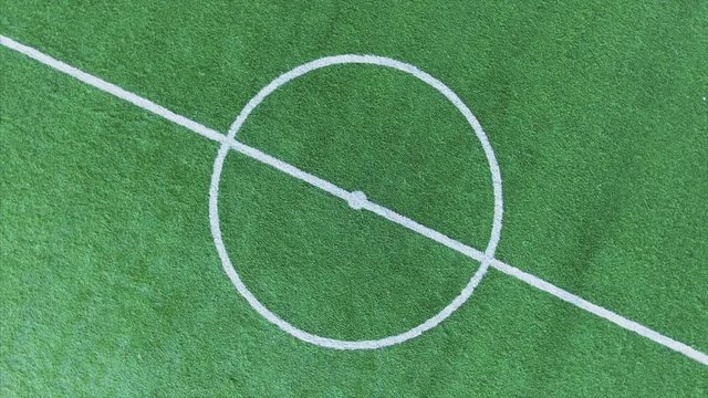 Cool aerial orbit shot of middle of empty soccer field. 