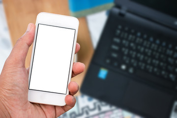 Hand holding mobile smart phone with blank screen in vertical position, blurred background - mockup template