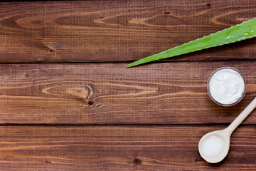 White beauty cream in jar with aloe vera wooden background