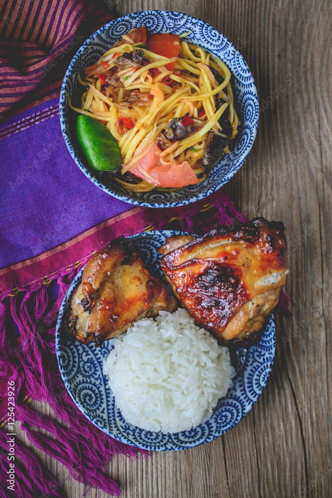 Wall mural Papaya Salad with Grilled Chicken and Sticky Rice on Wood Backgr