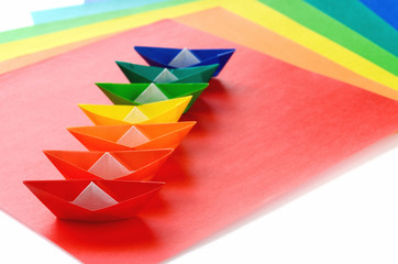 colorful origami ships on a white background
