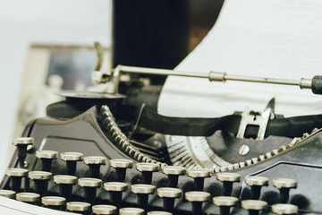 Close-up of old black typewriter with paper sheet