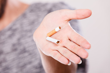 Closeup of broken cigarette on male hand.