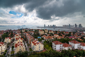 View of Old town and Qingdao bay from the hill of XiaoYuShan Park on a rainy summer day, Qingdao, China. 