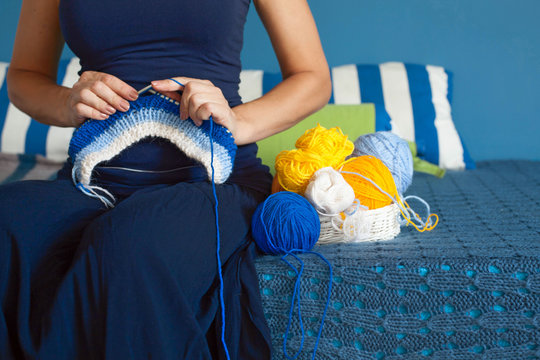 Woman in dark blue dress knit fabric of wool yarn.  