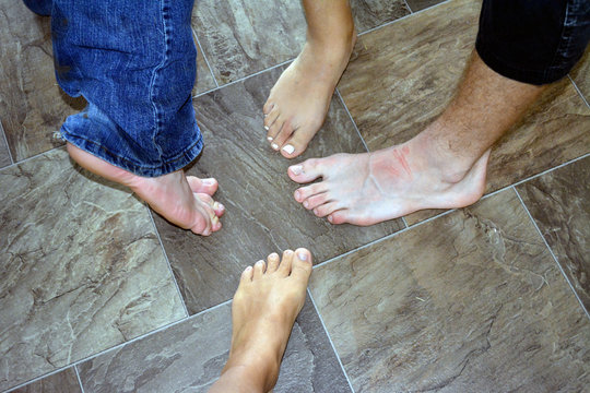 Four Feet/Four Bare feet standing on tile.