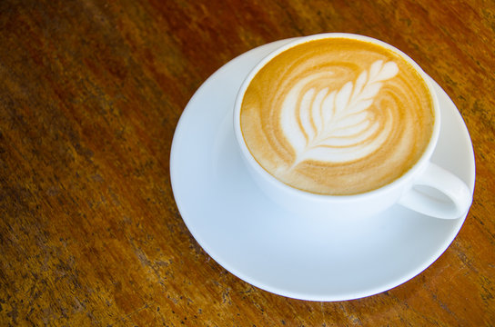 Hot Latte in White Cup with Leaf Latte Art Most Popular Drink Morning Coffee on Wood Table