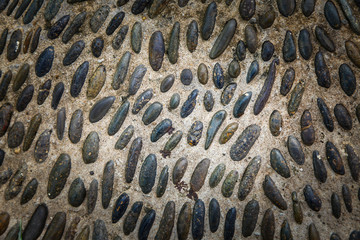 Round stones in the ground, Cobblestones in concrete background.