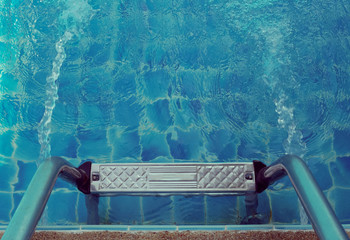 Grab bars ladder in the blue swimming pool. top view