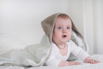 Baby kid under a hooded towel