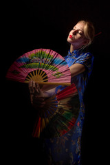 girl in japanese costume dancing with fans on black background