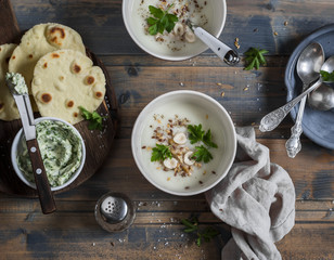 Cauliflower cream soup, corn tortillas and garlic herb butter on a wooden rustic table. Top view