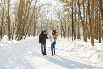 Fototapeta na wymiar Happy family - Mother, father and child boy on a winter walk.