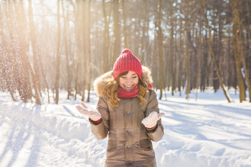 Fototapeta na wymiar Beauty Girl Blowing Snow in frosty winter Park. Outdoors. Flying Snowflakes.