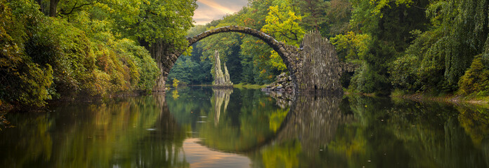 Autumn over Devil's bridge in the park Kromlau, Germany
 - obrazy, fototapety, plakaty
