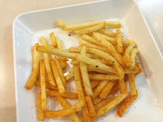 spicy french fries on white dish in restaurant, Thailand.