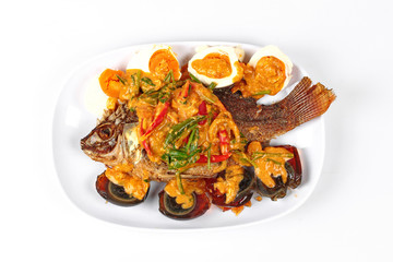 Curry-fried  tilapia fish with preserved egg and salted egg as topped a spicy curry with coconut milk.

