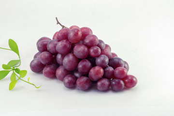 Ripe red grape with leaves isolated on white