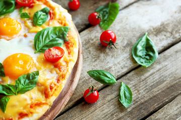 Margarita pizza with basil leaves and egg on wooden background