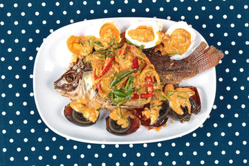 Curry-fried  tilapia fish with preserved egg and salted egg as topped a spicy curry with coconut milk.
