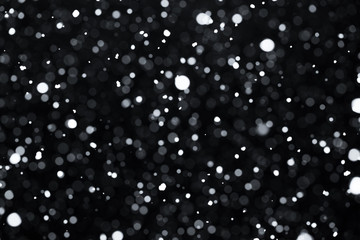 Falling snow on black background.