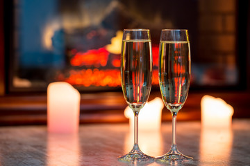 Beautiful two glasses of champagne standing on the table in the background of a blurred room with a decorated Christmas tree and candles. Soft focus. Shallow DOF
