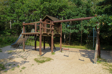Fototapeta na wymiar Wooden playground equipment with slides at summer time