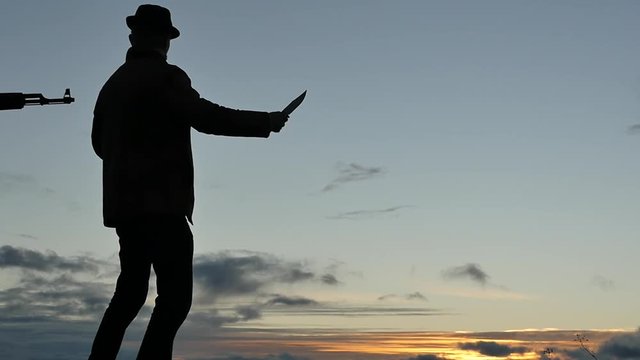 Man looking like gangster raising the hands and dropping a knife pushed by gun silhouette slow motion