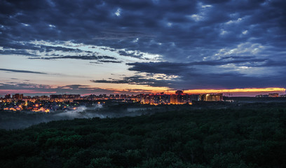 Obraz premium City sunset, beautiful sky and forest in the foreground