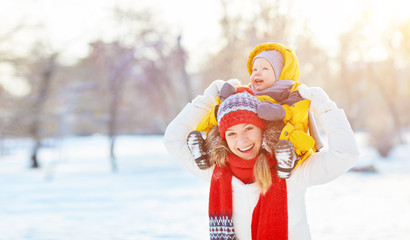 happy family mother and baby is happy snow on winter walk