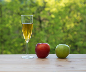 Wine glass red and green apples on table