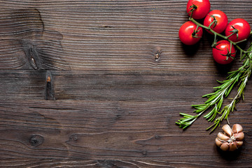 tomato, rosemary and garlic on wooden background top view