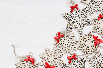 Christmas soft beige wooden snowflakes on a wood white  background. New Year frame background.