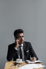 A beautiful successful man talking on phone office in cafe