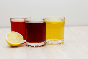 drinks of different colors and texture in glass cups on table on white background. A place for a label. Copyspace